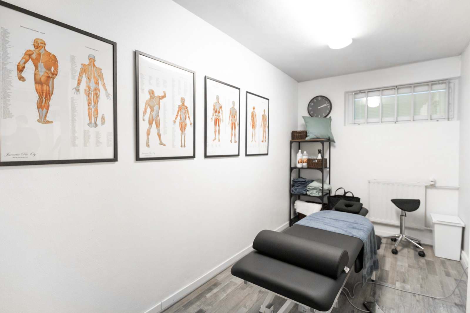 Hoitohuone anatomiajulisteineen, jossa urheiluhierontaa tehdään